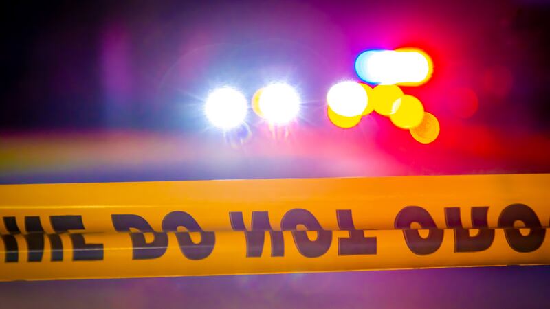 Generic and blurry police lights from a cruiser vehicle and car headlights behind yellow crime...