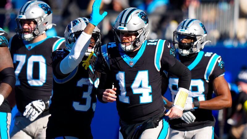 Carolina Panthers quarterback Sam Darnold celebrates after scoring during the first half of an...