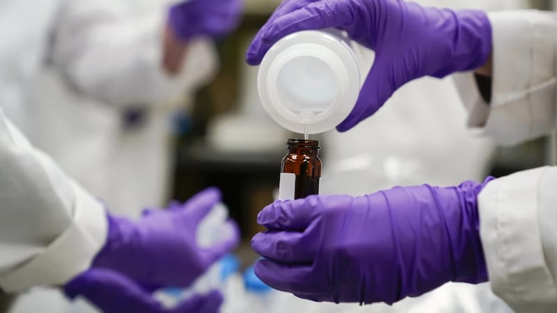 FILE - Eva Stebel, water researcher, pours a water sample into a smaller glass container for...