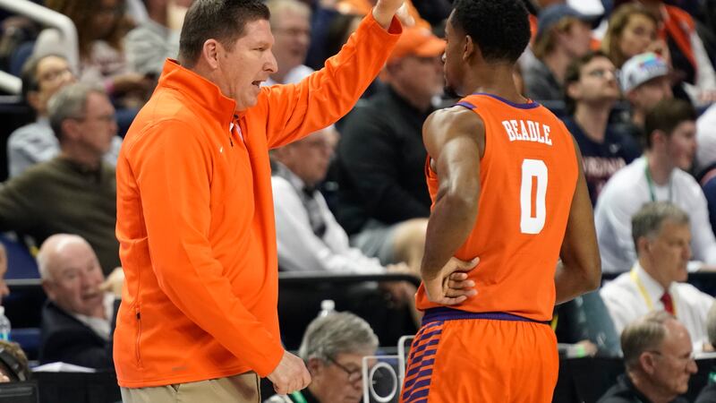 Clemson head coach Brad Brownell, left, talks with guard Kihei Clark (0) during the first half...